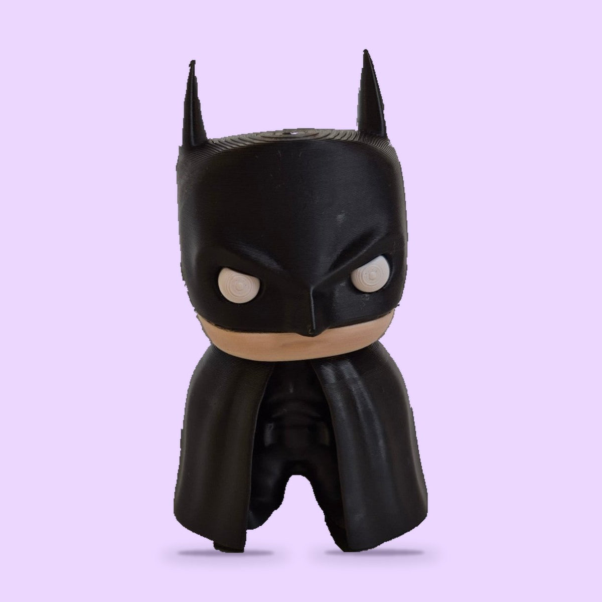 Batman em Estilo Boneco de Vinil com fundo lavanda e sombra de contato