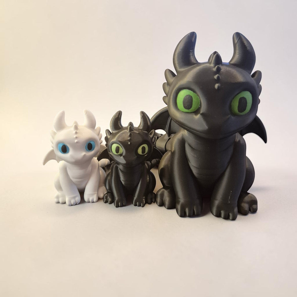 Bonecos articulados Minha loja dos dragões Banguela e Fúria da Luz em impressão 3D, nas cores preto e branco.