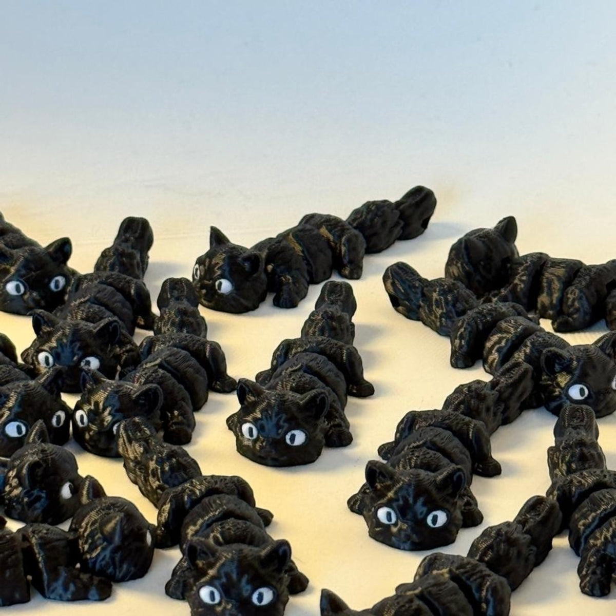 Chaveiros articulados de gato preto impressos em 3D da Minha loja, com design flexível e olhos expressivos.