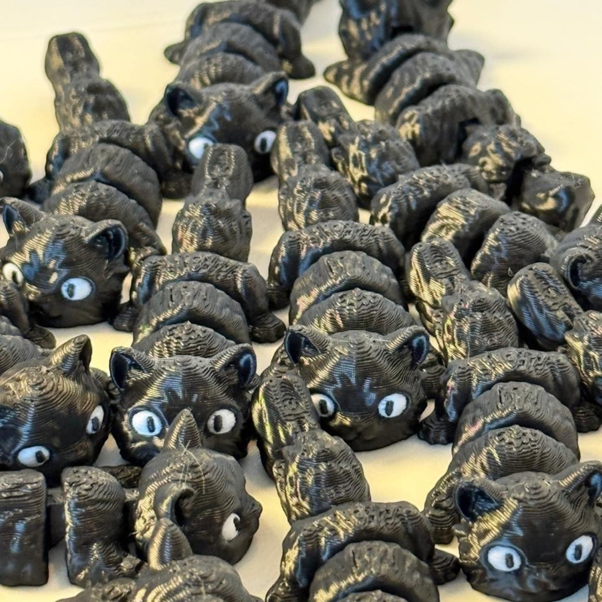 Chaveiros articulados Minha loja em formato de gatinhos pretos impressos em 3D com olhos brancos expressivos