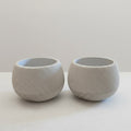 Dois vasos facetados Minha loja em impressão 3D, cor cinza claro, com textura de linhas modernas e design arredondado.